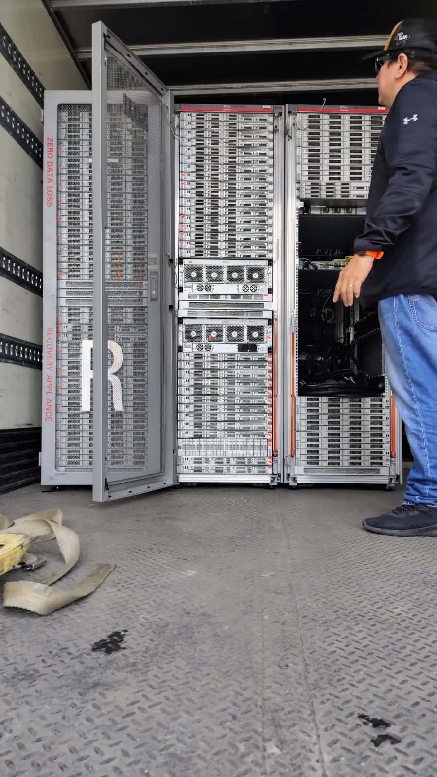 Técnico revisando racks de servidores cargados en la unidad de recolección