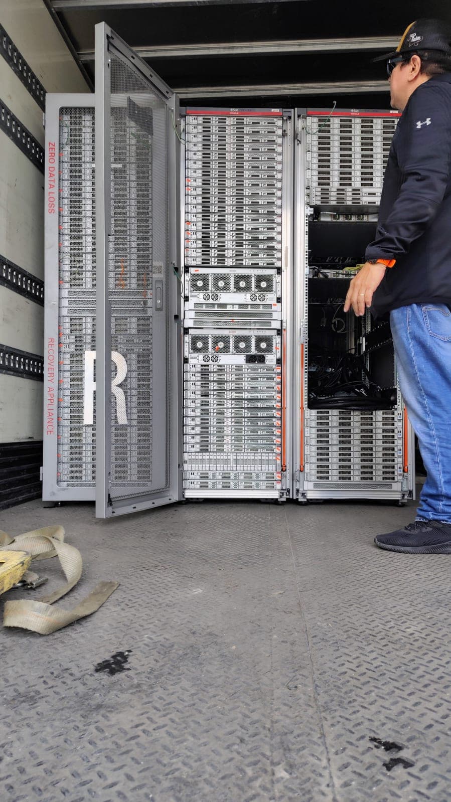 Técnico revisando racks de servidores cargados en la unidad de recolección