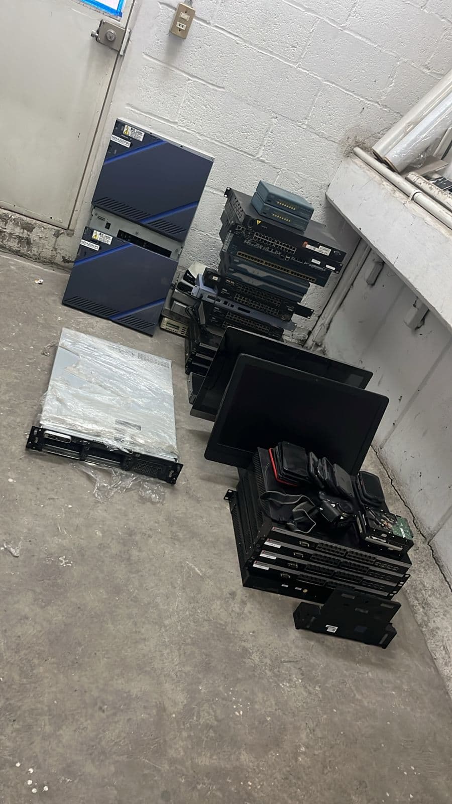 Servidores, monitores y switches reunidos en una oficina para su retiro