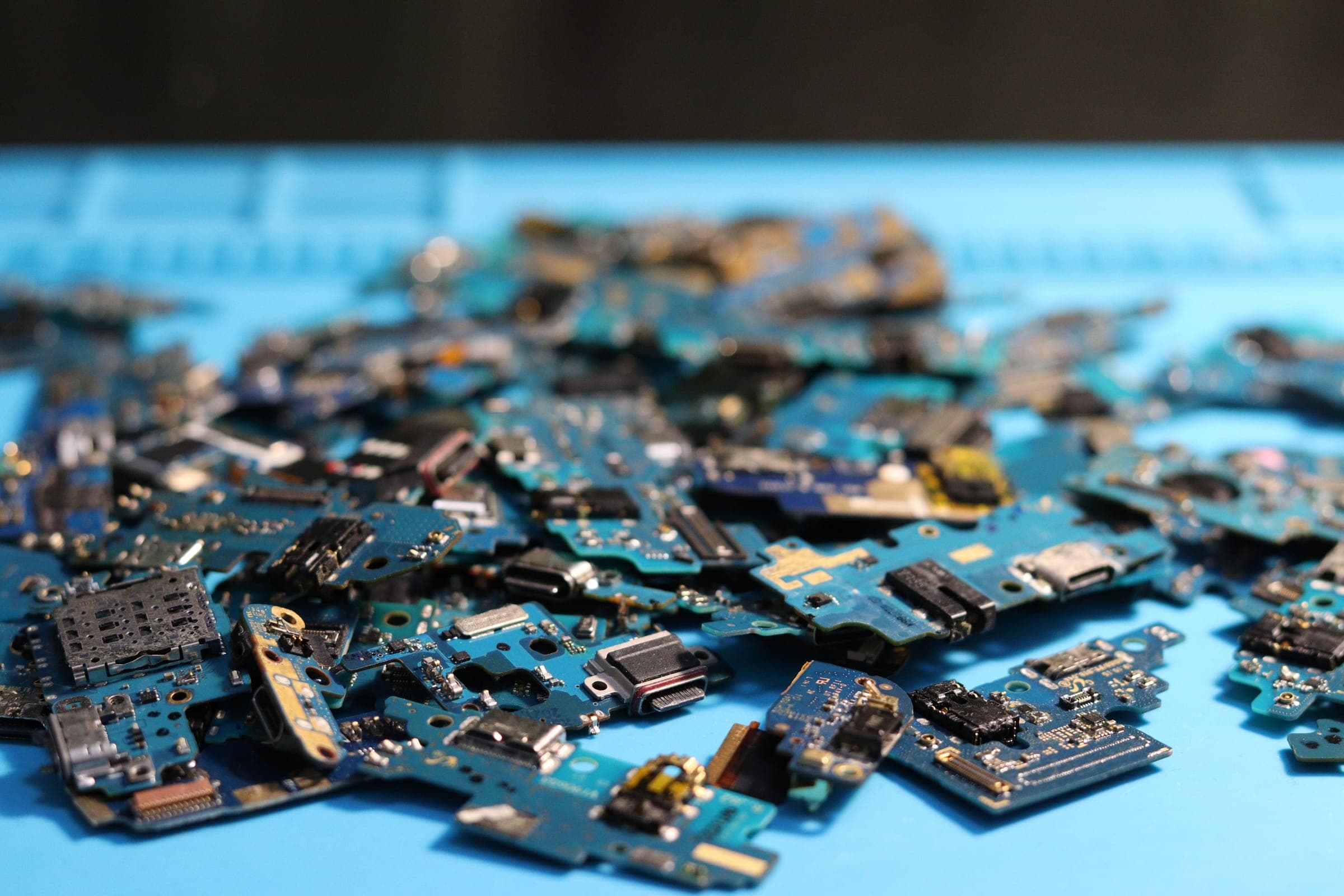 Placas de circuito de celulares desensambladas sobre una superficie azul