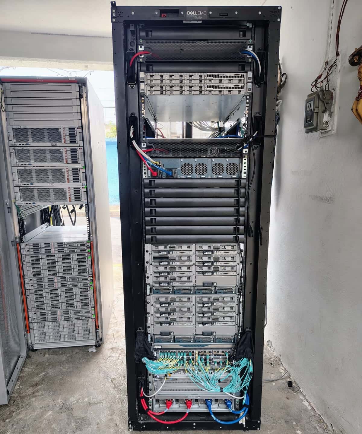 Rack de servidores con cableado de red en el site de un cliente, antes de su retiro